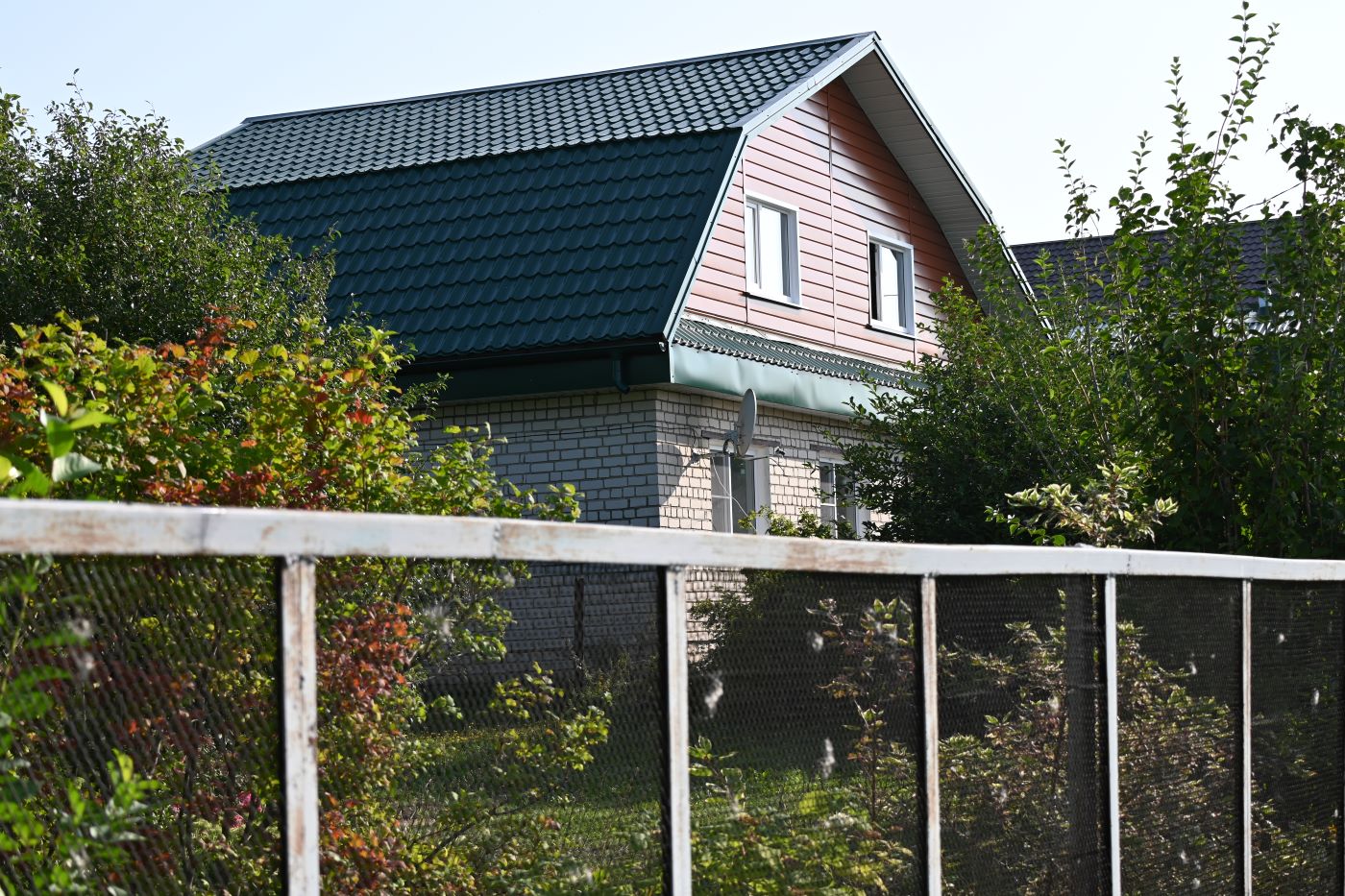 The slate roof was replaced with metal tiles. There is metal siding on the eaves and gable.